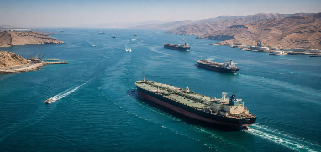 Oil tankers and cargo ships sailing through the Strait of Hormuz during negotiations over the proposed Iran Hormuz deal affecting Gulf maritime traffic.